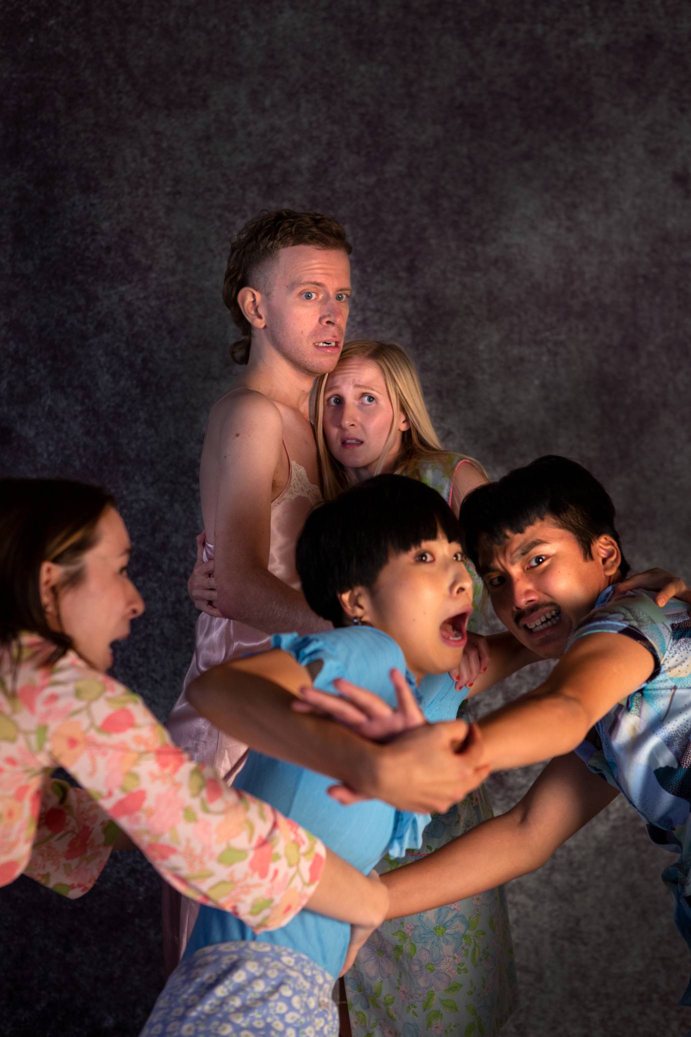 The cast, expressing fear on their faces, looks to an unseen adversary.