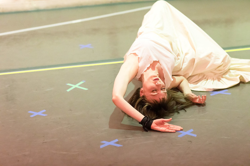 In a white dress, Alison Clancy lies crumpled on the floor