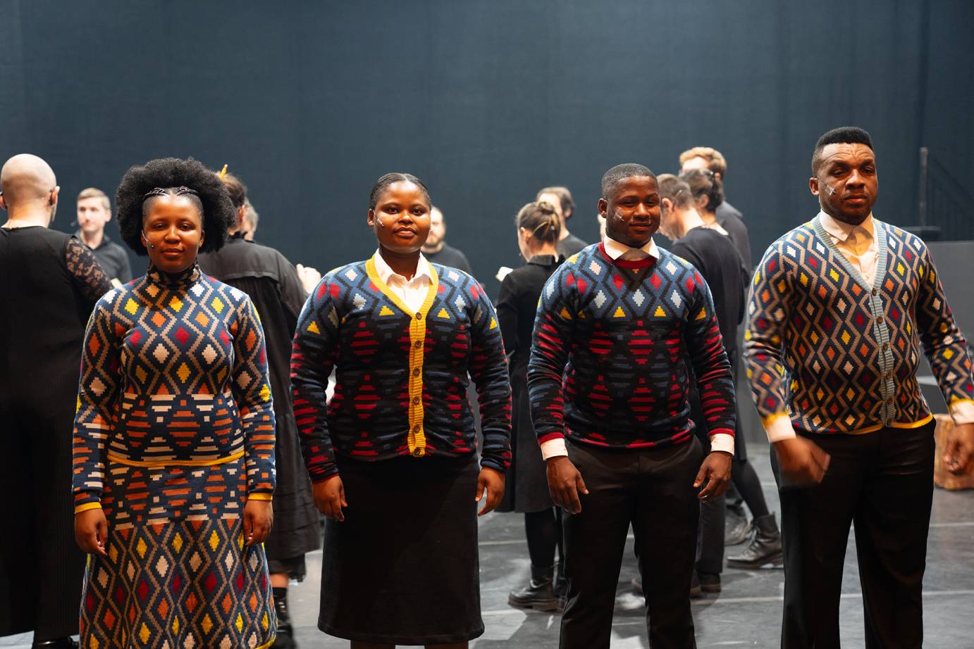 4 people stand in a line facing front