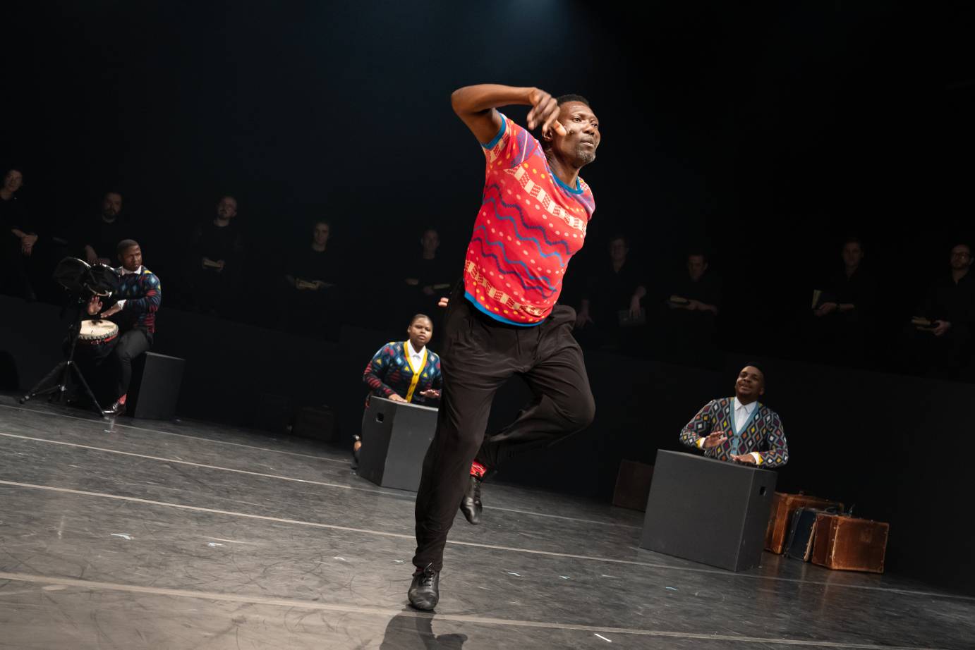 Dancer in bright red shirt jumping