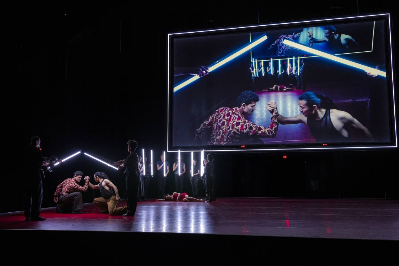 Two men are fighting, their hands clasped tightly staring intently at each other.