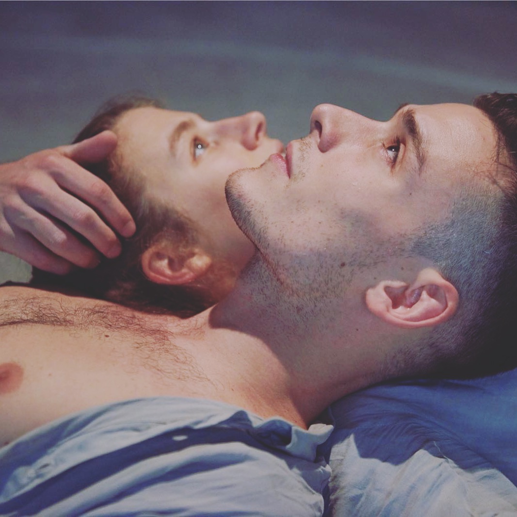 profile view of 2 figures faces staring upward