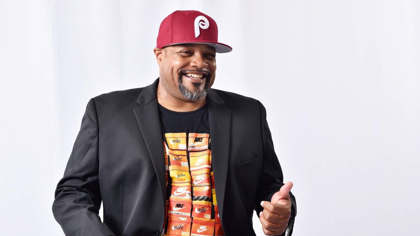 man with facial bright eyes in black shirt with yellow and orange images 