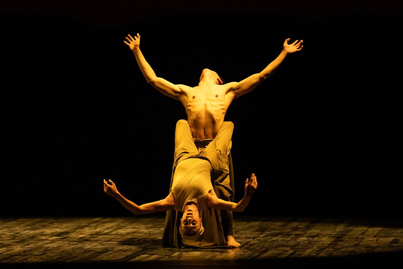 grabbing the mans waist with her legs surrounding his torso the woman leans backwards her body grazing the floor