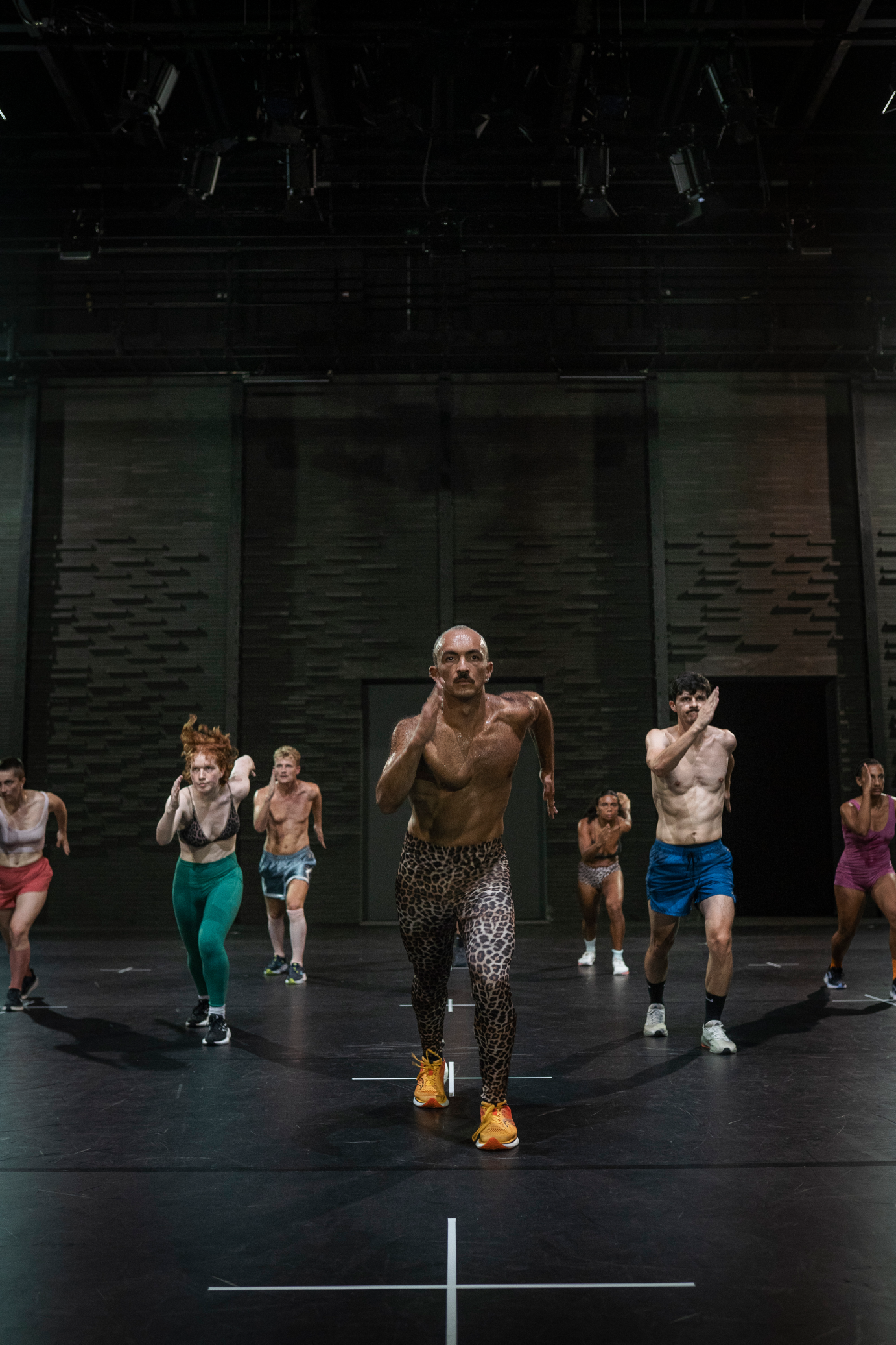 The dancers in an evenly spaced grouping, swing their right arms forward, fingers long and together, as they step downstage with the left legs, faces front.