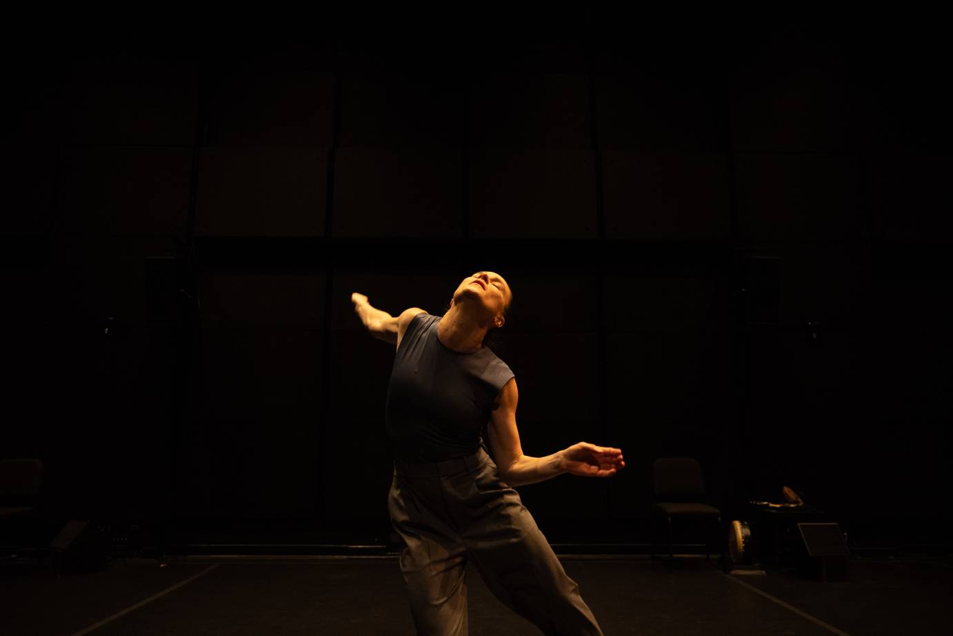 A woman with her face to ceiling eyes closed bathed in golden light.