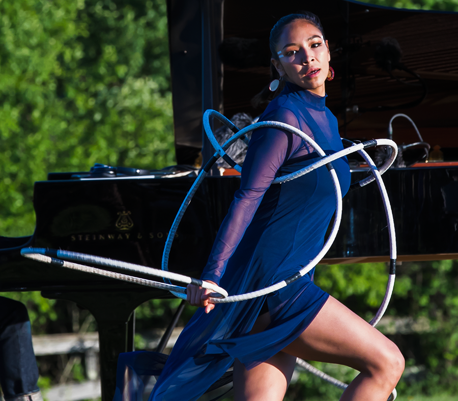 ShanDien LaRance in her gorgeous royal blue outfit moves through her hoops, dancing inside them and peering off to the right as if in contemplation. 