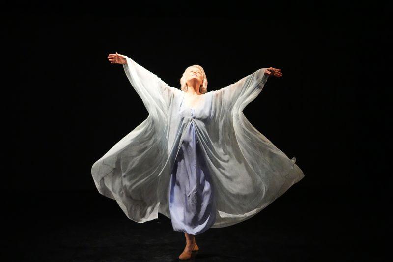 woman in a gauzey shift , standing with arms in a v shaped, on her toes, like Isadora Duncan