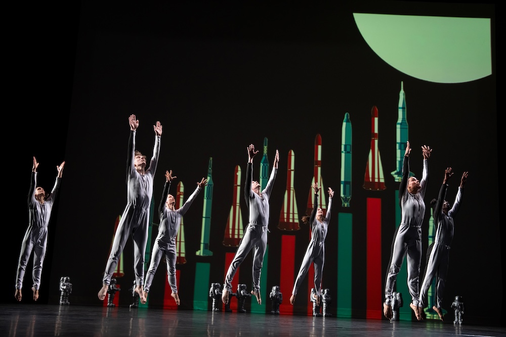 dancers along side prop rocket ships reaching for the sky