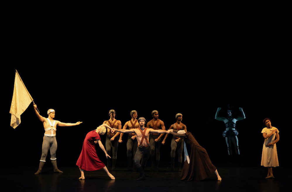 A Soldier threatens the group of war torn people