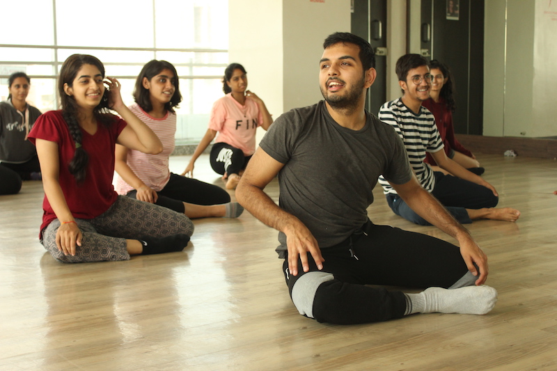 A group of dancers sit on the floor