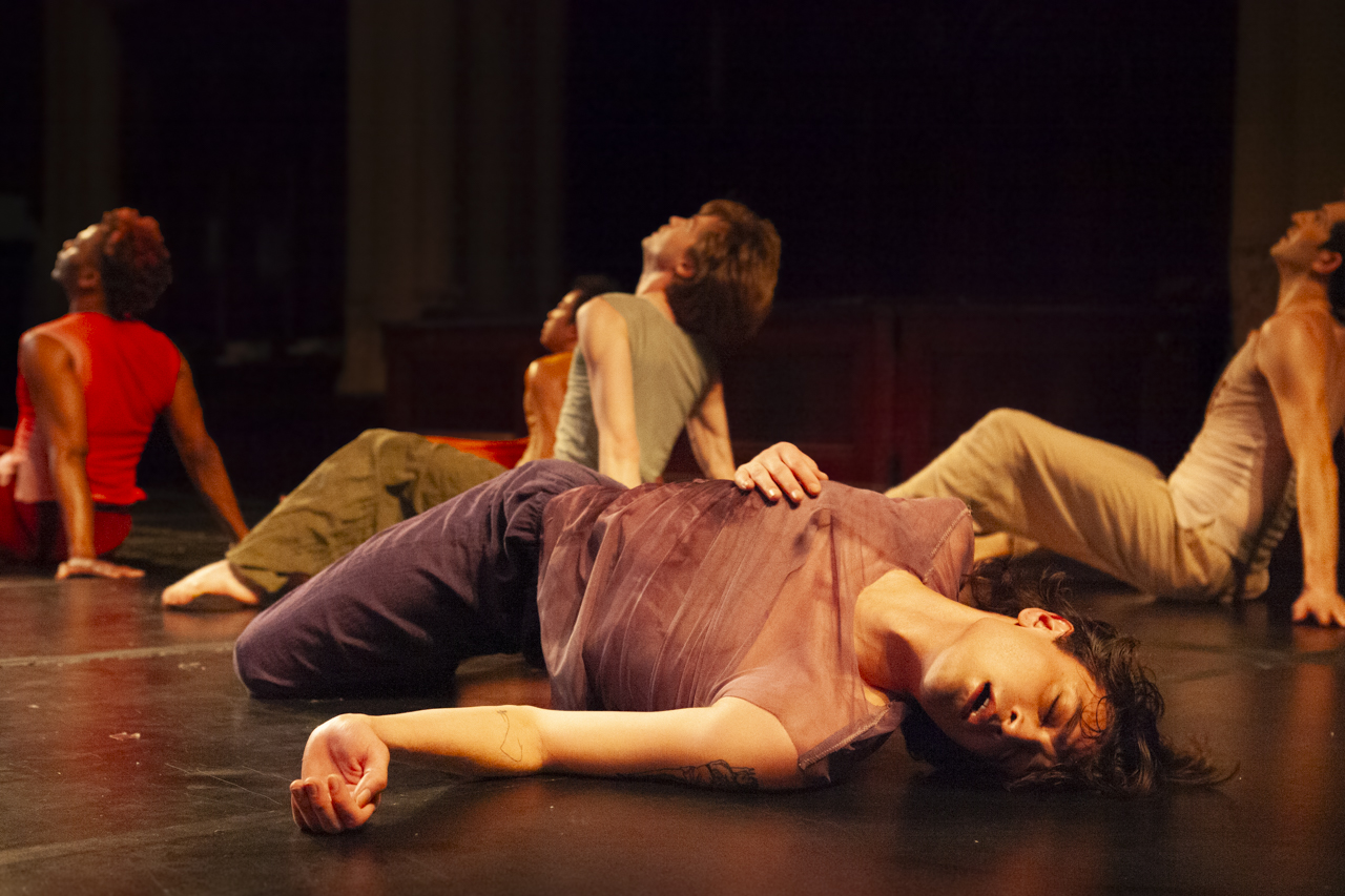 A man, sprawled on his back, with arms resting on his body, mouth open and eyes closed.